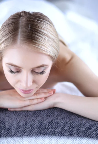 Ung kvinna liggande på ett massagebord, avslappnande med slutna ögon. Kvinnan. Spasalong — Stockfoto