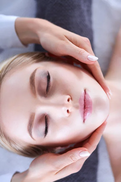 Jeune femme allongée sur une table de massage, relaxante les yeux fermés. Femme. Salon de spa — Photo