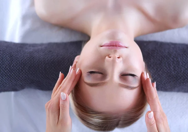 Mujer joven acostada en una mesa de masaje, relajándose con los ojos cerrados. Una mujer. Salón de spa — Foto de Stock