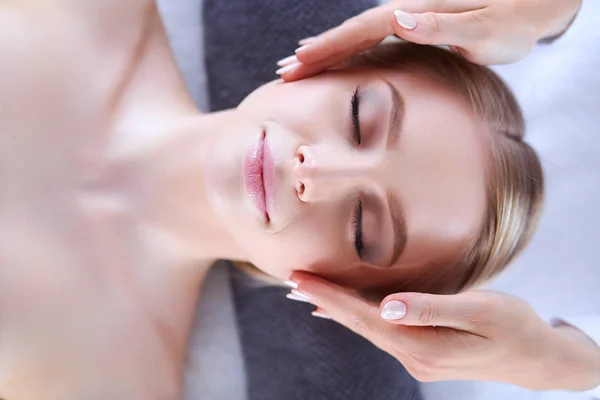 Jeune femme allongée sur une table de massage, relaxante les yeux fermés. Femme. Salon de spa — Photo