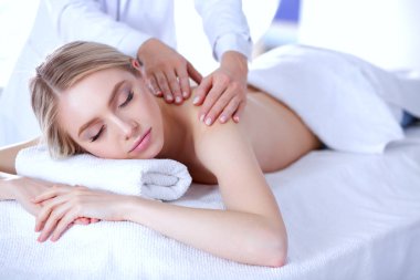 Masaj masasında uzanmış gözleri kapalı rahatlayan genç bir kadın. - Kadın. Spa salonu