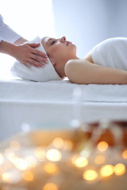 Masaj masasında uzanmış gözleri kapalı rahatlayan genç bir kadın. - Kadın. Spa salonu