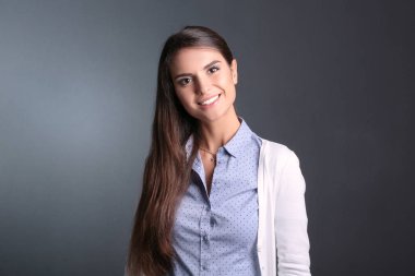 Esmer arka planda bir iş kadınının portresi. Gülümseyen kadın. Bir kadın portresi