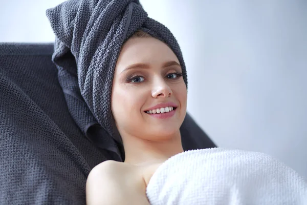 Mujer joven acostada en una mesa de masaje, relajada. Una mujer. Salón de spa —  Fotos de Stock