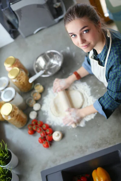 Schöne Frau beim Kuchenbacken in Küche neben Schreibtisch. — Stockfoto