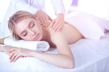 Masaj masasında uzanmış gözleri kapalı rahatlayan genç bir kadın. - Kadın. Spa salonu