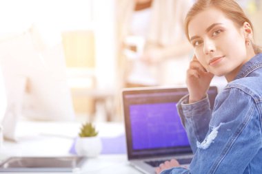 İki genç kadın masada enstrümanlar, planlar ve dizüstü bilgisayarlarla oturuyor..