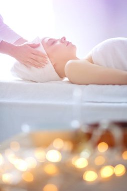Masaj masasında uzanmış gözleri kapalı rahatlayan genç bir kadın. - Kadın. Spa salonu