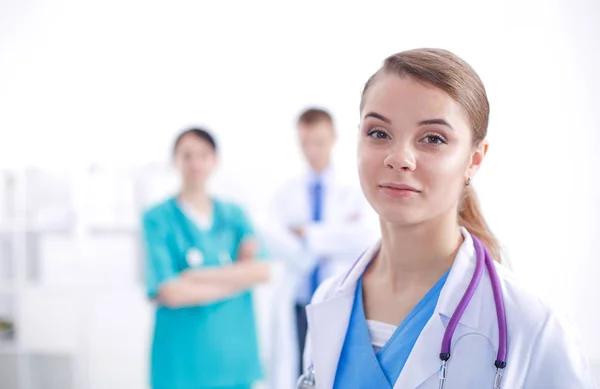 Attractive female doctor in front of medical group. — Stock Photo, Image