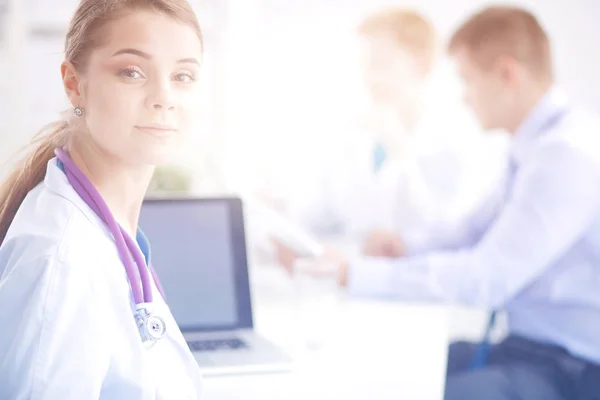 Attractive female doctor in front of medical group.