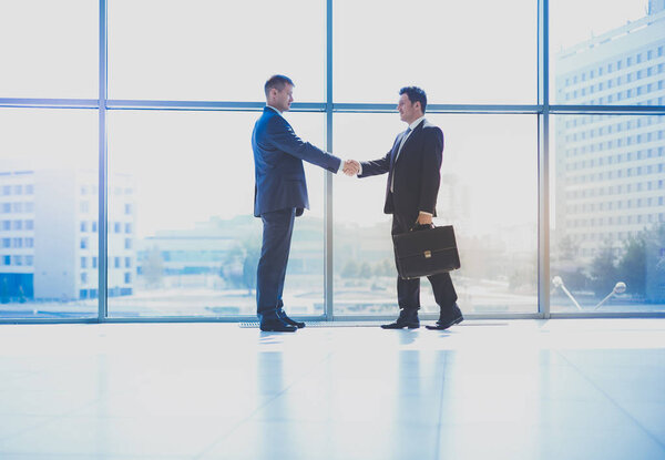 Изображение двух успешных бизнесменов, пожимающих друг другу руки