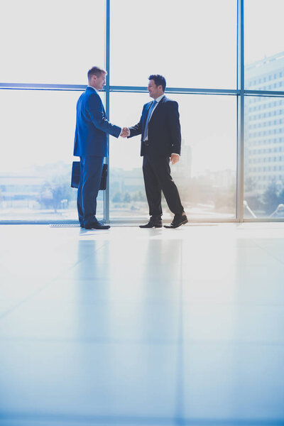 Изображение двух успешных бизнесменов, пожимающих друг другу руки