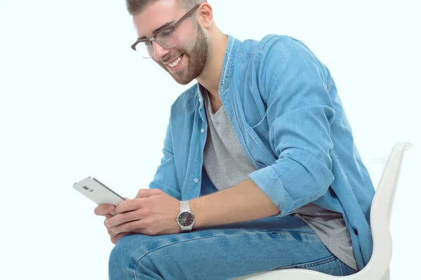 Junger Mann auf Stuhl sitzend und mit Handy. Startupper. Jungunternehmer. — Stockfoto