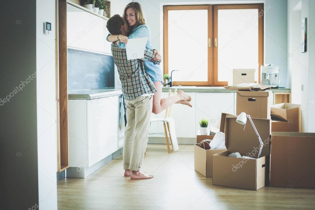 Portrait of young couple moving in new home. Young couple