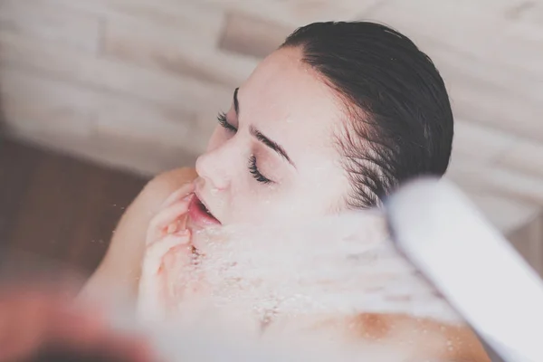 Junge schöne Frau unter der Dusche im Badezimmer. — Stockfoto