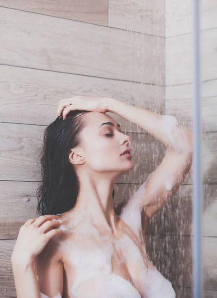 浴室のシャワーの下で若い美しい女性. — ストック写真