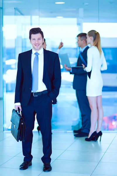 Portret van een jonge zakenman met collega 's op de achtergrond. Portret van een jonge zakenman. — Stockfoto