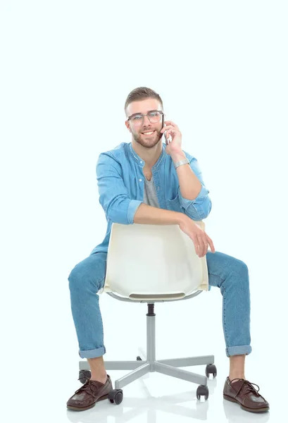 Jeune homme assis sur une chaise et utilisant un téléphone portable. Démarreur. Jeune entrepreneur . — Photo