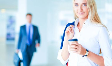 Yound kadın ayakta ofisindeki kahve içmek