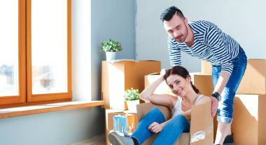 Mutlu genç çift açma veya kutu ambalaj ve yeni evine taşıdıktan