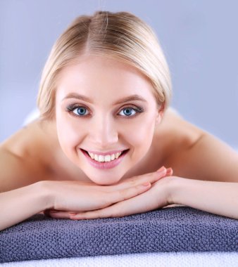 Gözleri kapalı rahatlatıcı bir masaj masanın üzerinde yatan genç kadın