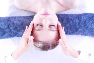 Gözleri kapalı rahatlatıcı bir masaj masanın üzerinde yatan genç kadın