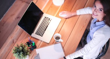 Masasında oturan ve elinde bir fincan kahveyle rahatlamış genç bir kadının portresi. İş kadını. İşyeri