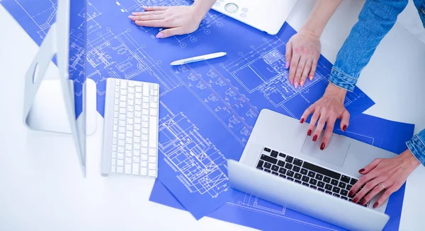 Two young woman standing near desk with instruments, plan and la — Stock Photo, Image