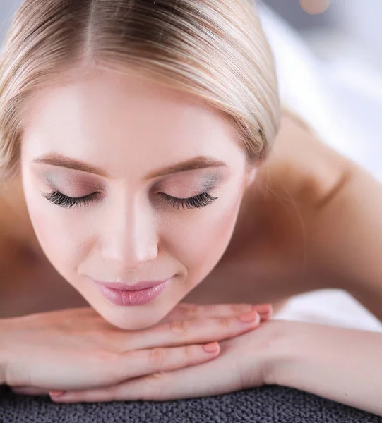 Young woman lying on a massage table,relaxing with eyes closed — Stock Photo, Image