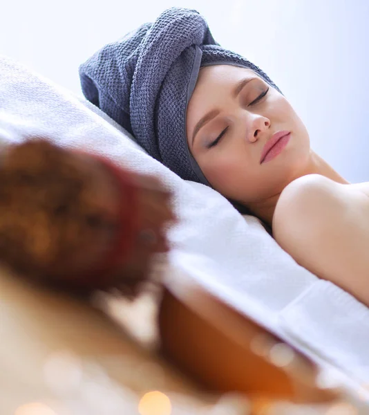 Young woman lying on a massage table,relaxing with eyes closed — Stock Photo, Image