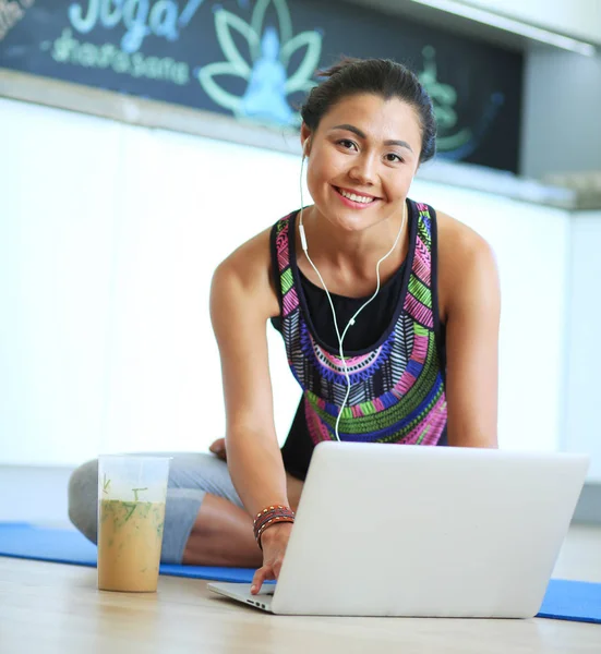 Deportiva mujer sonriente utilizando el ordenador portátil en la habitación luminosa. Una mujer. Estilo de vida — Foto de Stock