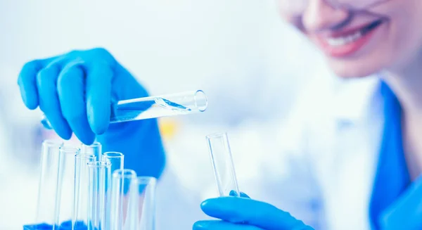 Woman researcher is surrounded by medical vials and flasks, isolated on white background — Stock Photo, Image