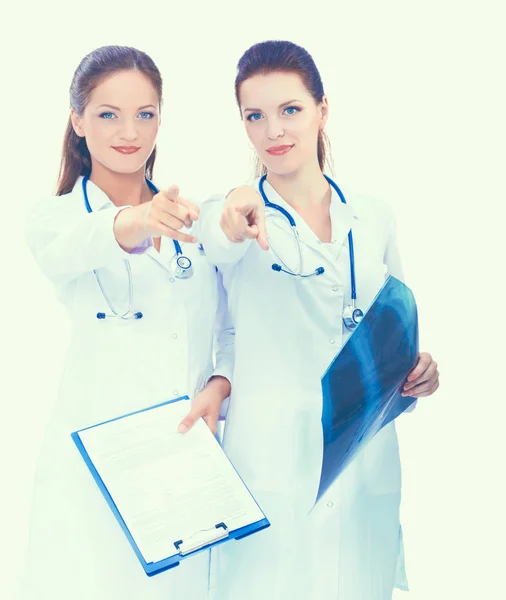 Две медсестры смотрят рентгеновские снимки, стоят в больнице и указывают тебе — стоковое фото