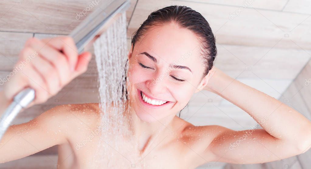 Young beautyful woman under shower in bathroom