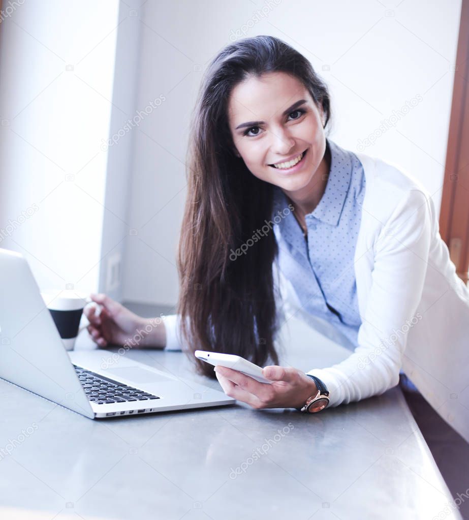 Young female standing near desk. Woman in the kitchen. Workplace