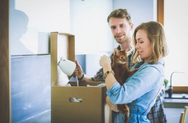 Genç bir çift yeni evde büyük karton kutu taşıyan. Ev taşıma. Genç Çift