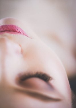 Masaj masasında uzanmış gözleri kapalı rahatlayan genç bir kadın. - Kadın. Spa salonu