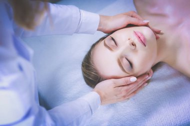 Masaj masasında uzanmış gözleri kapalı rahatlayan genç bir kadın. - Kadın. Spa salonu