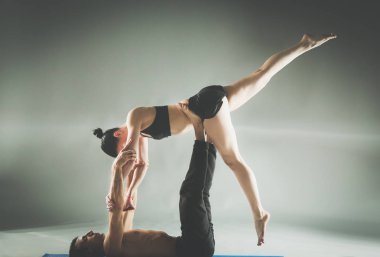 Genç çift Acro yoga mat Studio birlikte uygulamak. Acroyoga. Çift yoga. Ortak yoga.