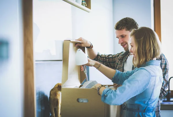 Casal jovem carregando grande caixa de papelão em casa nova. Casal jovem — Fotografia de Stock