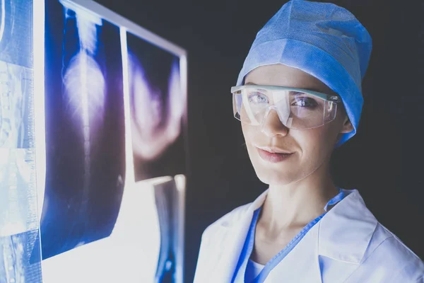 Зображення привабливої жінки-лікаря, який дивиться на результати рентгенівського випромінювання . — стокове фото
