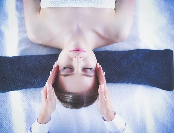Jeune femme allongée sur une table de massage, relaxante les yeux fermés. Femme. Salon de spa — Photo