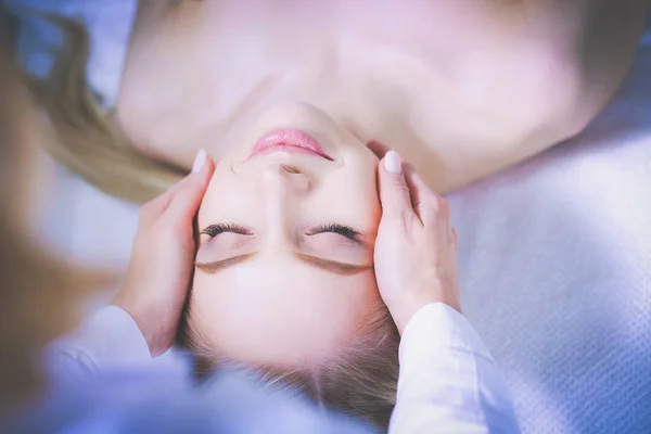 Junge Frau auf Massagetisch liegend, entspannt mit geschlossenen Augen. Frau. Wellness Salon — Stockfoto