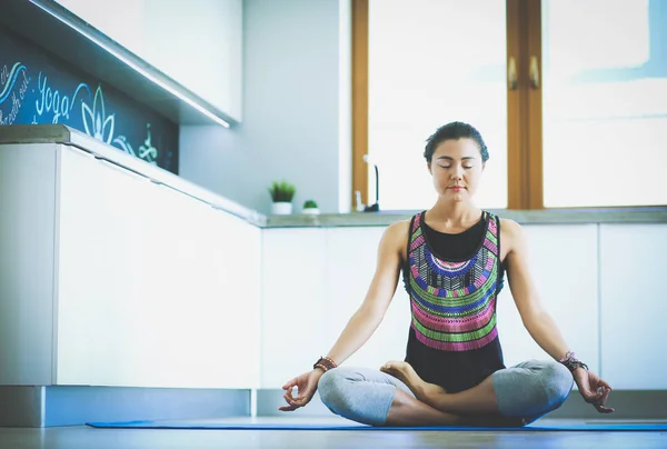 Mujer joven haciendo yoga en casa en la posición de loto. Yoga. Una mujer. Estilo de vida — Foto de Stock