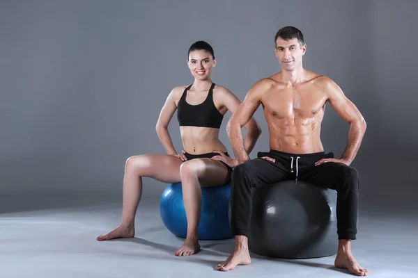 Two smiling people with fitness ball in the gym. Personal fitness instructor. Personal training. Gym workout.