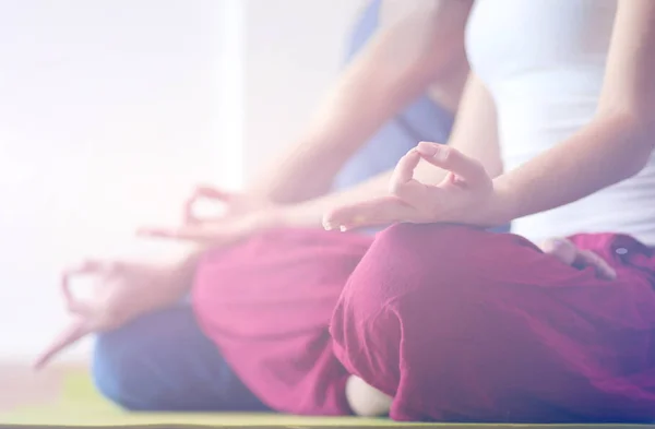 Young healthy couple in yoga position on white background