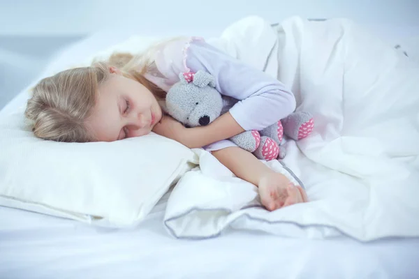 어린이 장난감 테 디 베어와 함께 침대에서 자는 어린 소녀 — 스톡 사진