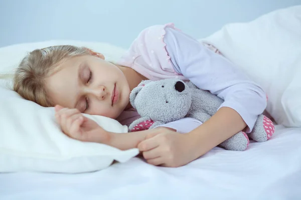 子供グッズ テディベアとベッドで眠る少女 — ストック写真