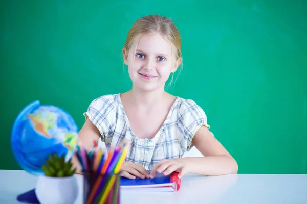 Chica estudiando en el escritorio, sentada en el escritorio —  Fotos de Stock