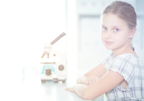 Skolflicka tittar genom mikroskopet i science klass — Stockfoto